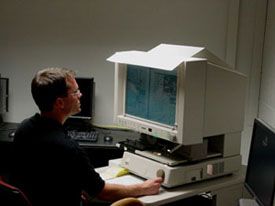 Historicus bij een microfiche-leesapparaat
